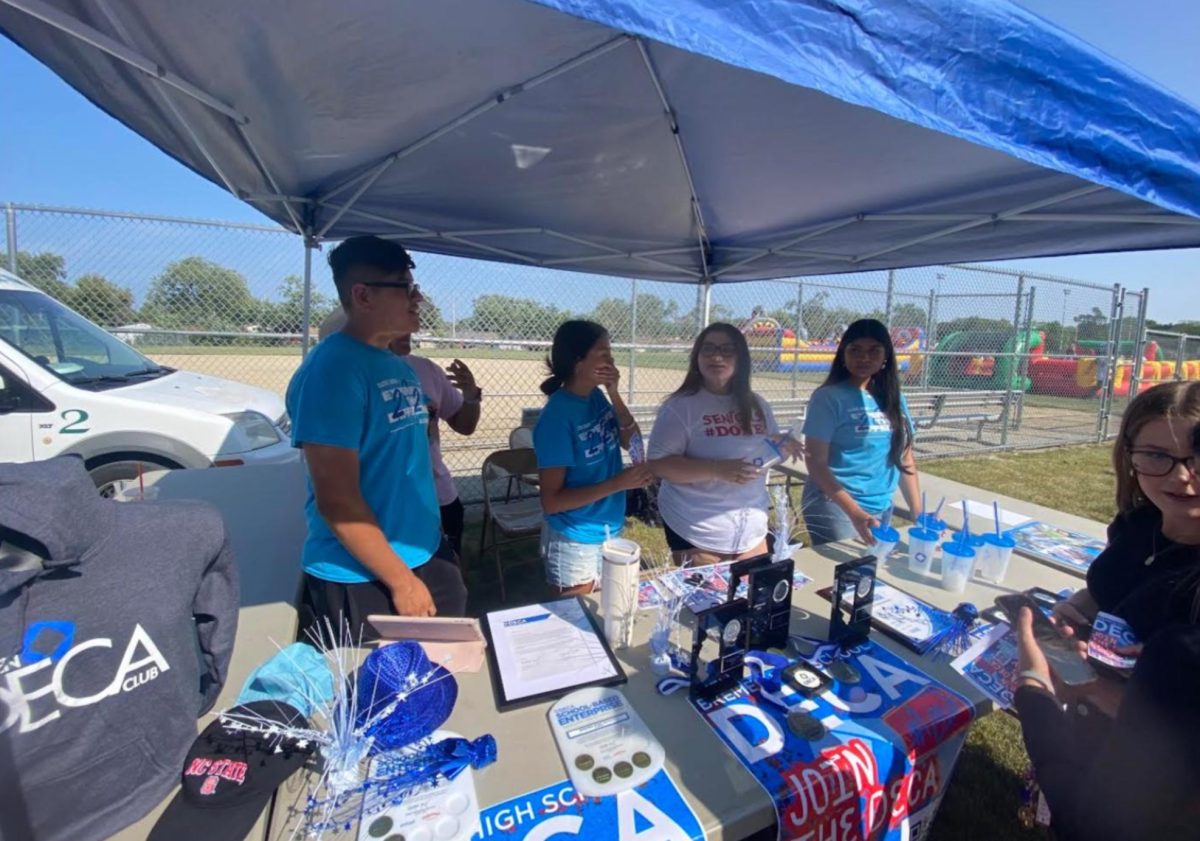 DECA students promote their club and its activities at the Aug. 23 Back-to-School Bash. Various clubs and sports hosted tables to encourage students to participate in the extracurricular offerings at Bremen. The Bash had a DJ, food trucks, inflatable games and more to promote school spirit.